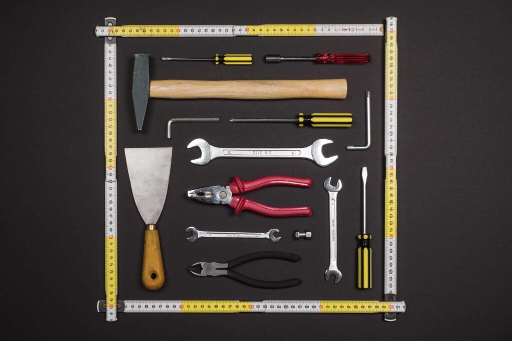 Basic home maintenance tools laid out on a wooden surface