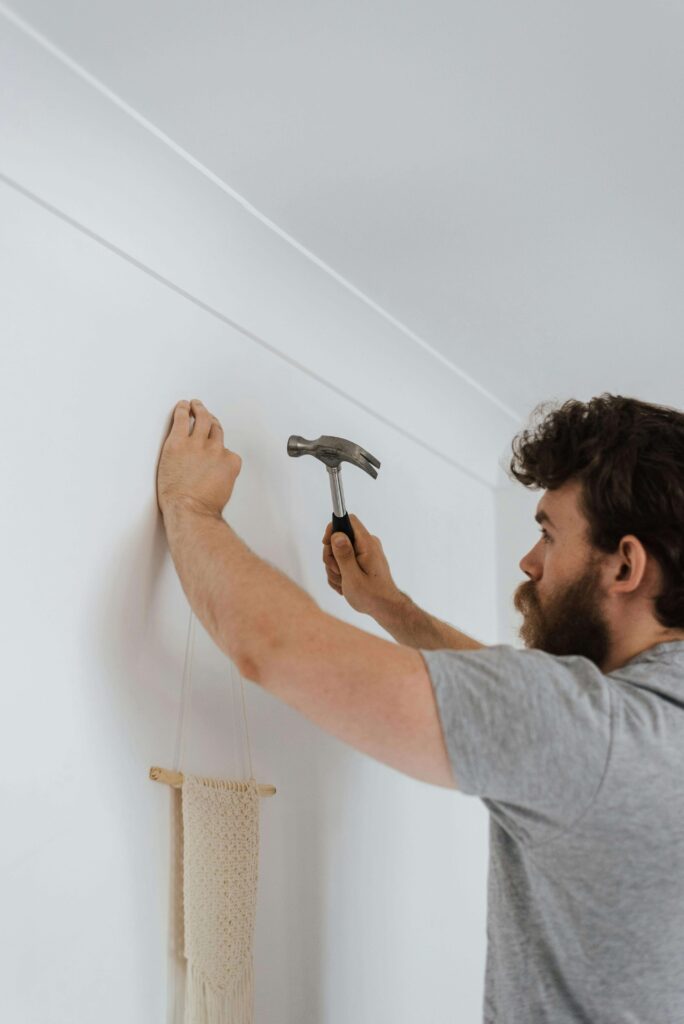 Person hanging a picture frame using basic tools
